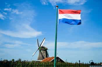 A flag against the blue sky on a pole.